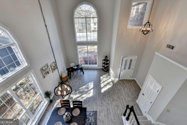 entryway featuring a high ceiling, hardwood / wood-style floors, and a chandelier