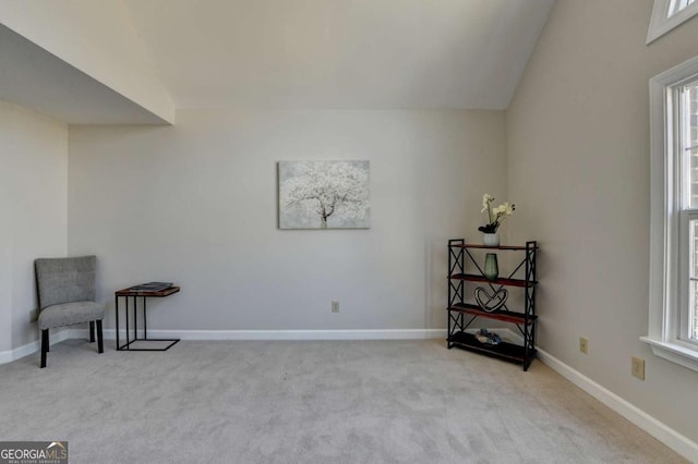 living area with vaulted ceiling, light carpet, and a wealth of natural light