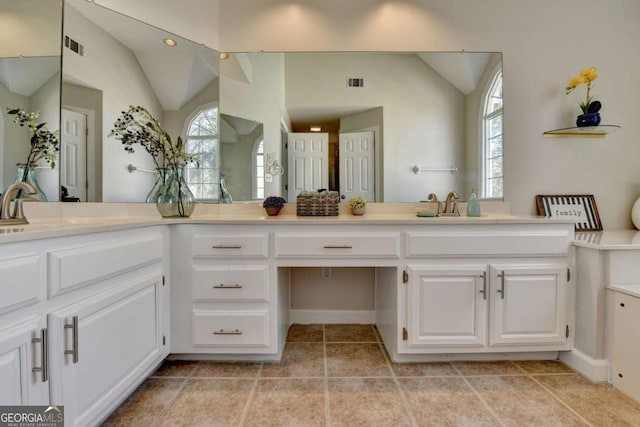 bathroom with tile patterned floors, lofted ceiling, and vanity