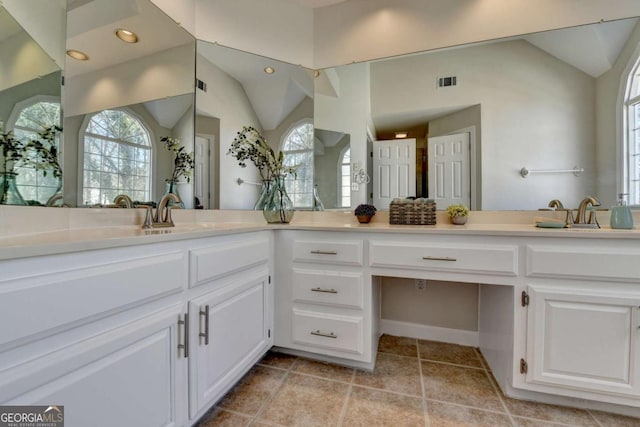 bathroom featuring a wealth of natural light, lofted ceiling, and vanity