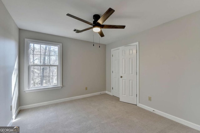 spare room with light colored carpet and ceiling fan