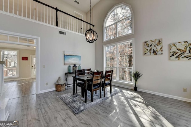 dining room featuring a high ceiling, hardwood / wood-style floors, and plenty of natural light