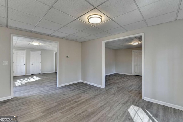 unfurnished room featuring a drop ceiling and wood-type flooring