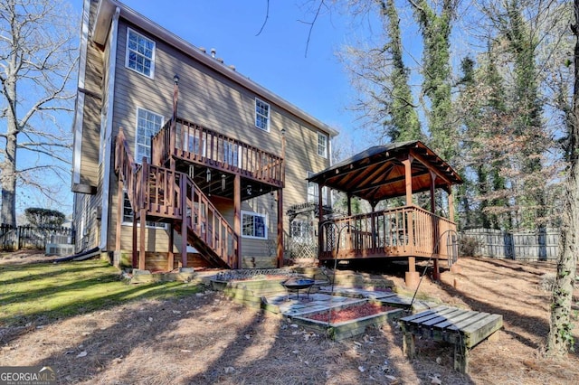 back of house featuring a gazebo, a deck, and a fire pit