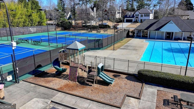 view of swimming pool featuring a playground and tennis court