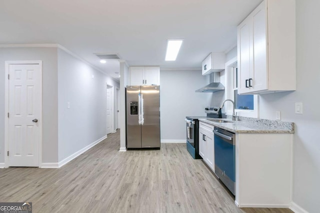 kitchen with white cabinets, sink, wall chimney exhaust hood, appliances with stainless steel finishes, and light stone counters