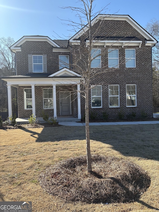 view of front of house with a front yard and a porch