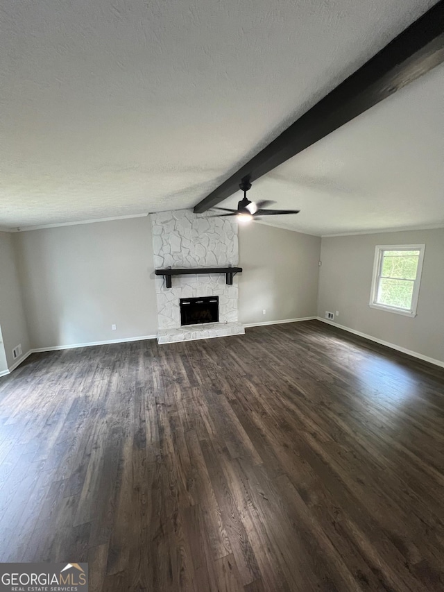 unfurnished living room with dark hardwood / wood-style floors, ceiling fan, vaulted ceiling with beams, a textured ceiling, and a fireplace