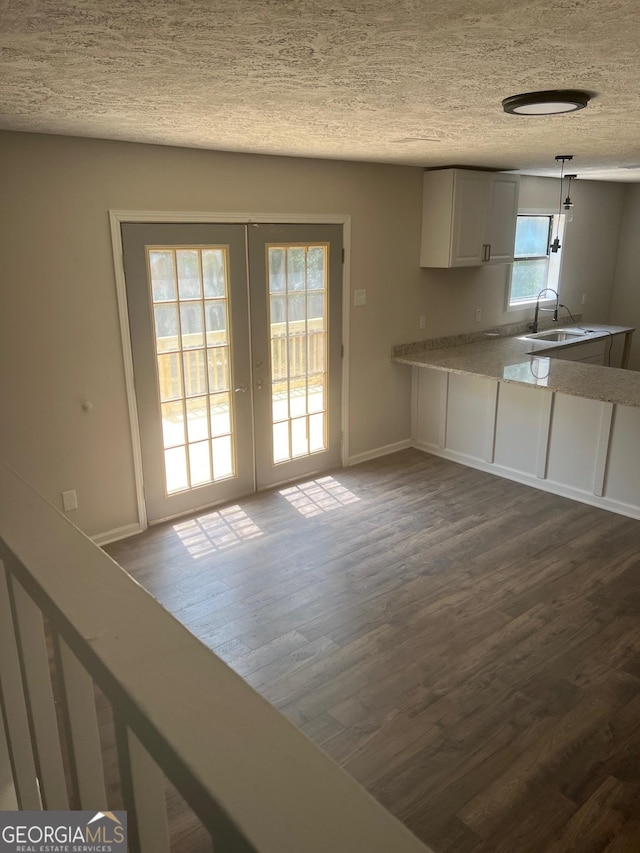 kitchen featuring french doors, dark hardwood / wood-style floors, a textured ceiling, decorative light fixtures, and white cabinets