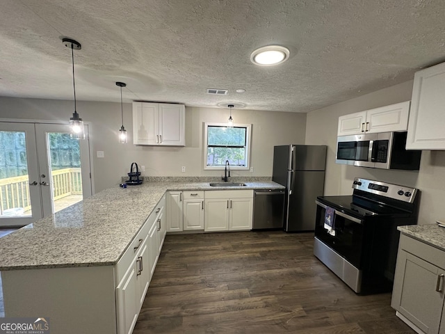 kitchen featuring appliances with stainless steel finishes, white cabinetry, french doors, and sink