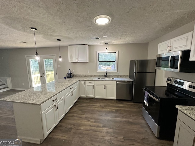 kitchen with kitchen peninsula, stainless steel appliances, white cabinets, and sink