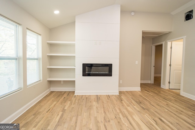 unfurnished living room with built in shelves, light hardwood / wood-style floors, and lofted ceiling