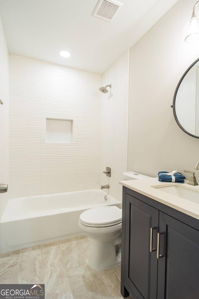 full bathroom with vanity, tiled shower / bath combo, and toilet