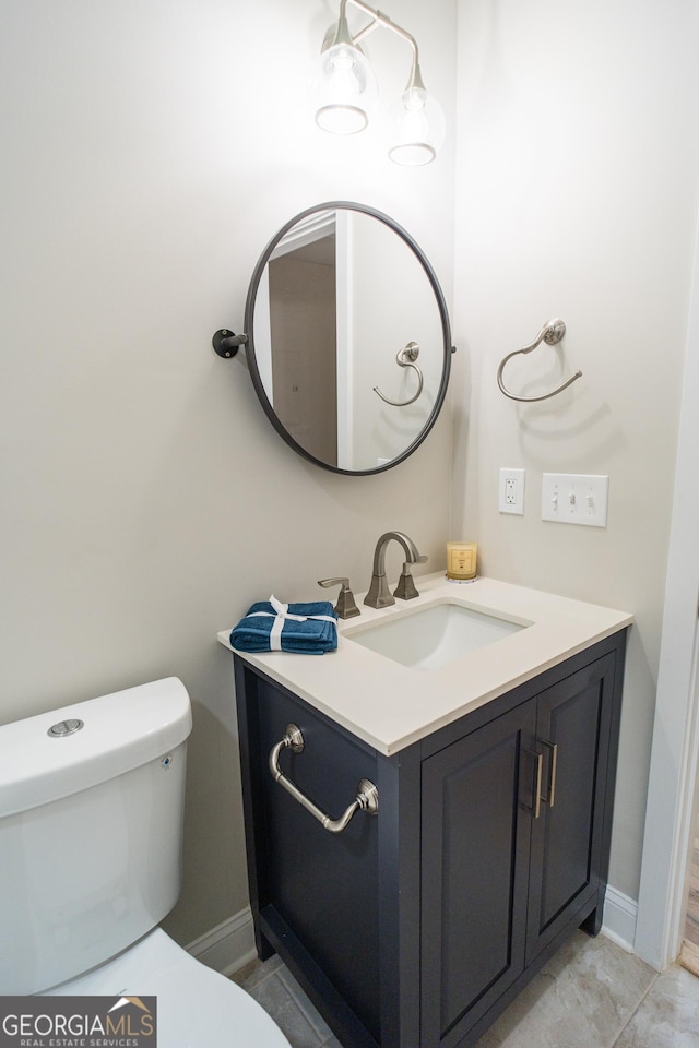 bathroom featuring tile patterned flooring, vanity, and toilet