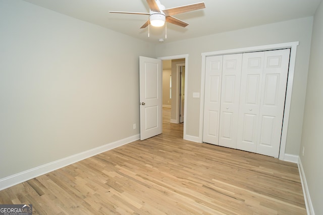 unfurnished bedroom featuring ceiling fan, light wood-type flooring, and a closet