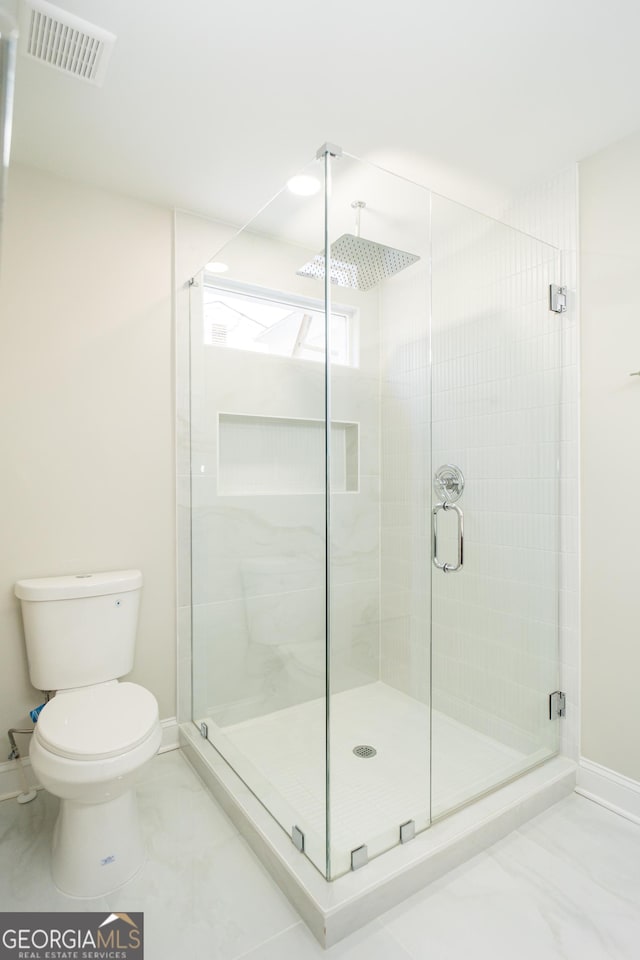 bathroom with toilet and a shower with shower door