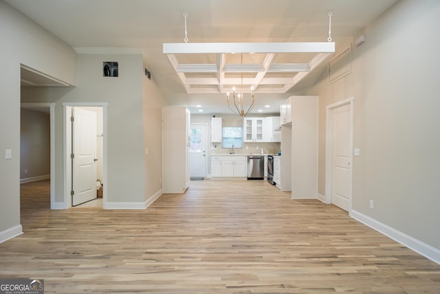 unfurnished living room featuring beam ceiling, sink, coffered ceiling, an inviting chandelier, and light hardwood / wood-style flooring