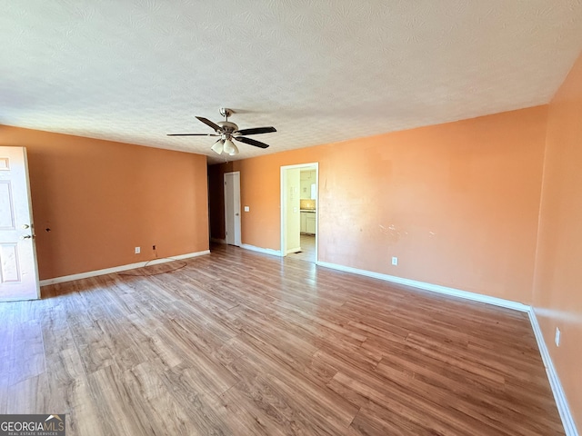 empty room with ceiling fan, light hardwood / wood-style floors, and a textured ceiling