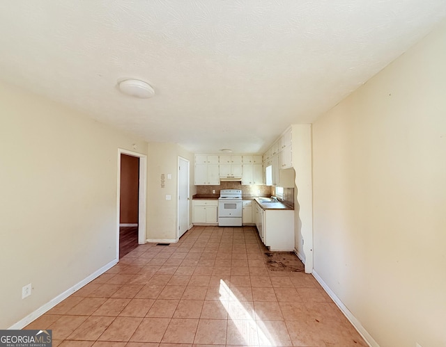 kitchen featuring backsplash, white cabinets, sink, white electric range oven, and light tile patterned flooring