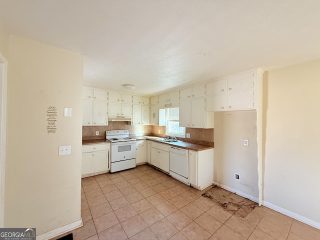 kitchen featuring light tile patterned floors, white cabinets, white appliances, and sink