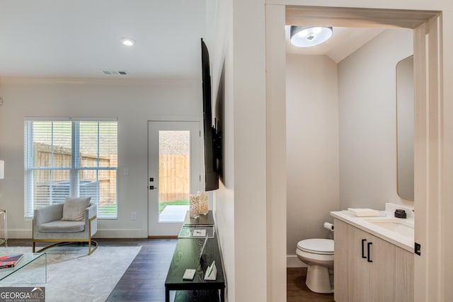 bathroom with toilet, vanity, and hardwood / wood-style flooring