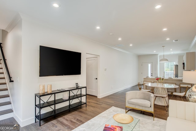 living room featuring hardwood / wood-style flooring and crown molding