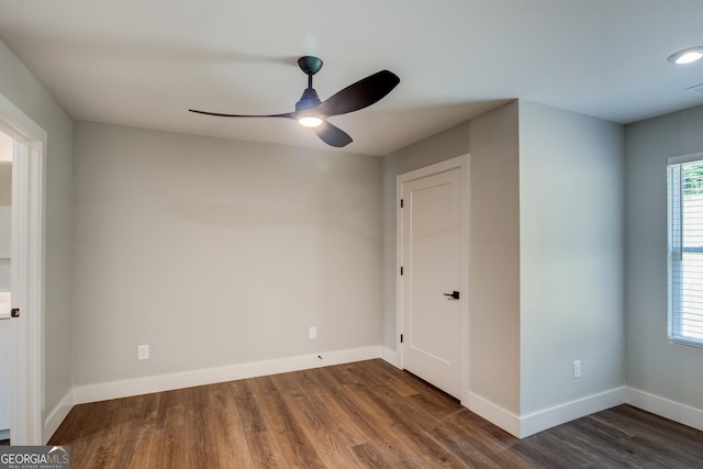 unfurnished room with ceiling fan and dark wood-type flooring