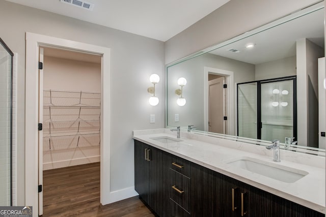 bathroom featuring a shower with shower door, vanity, and hardwood / wood-style flooring