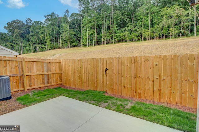 view of yard with central AC unit and a patio