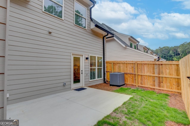 back of property with central AC and a patio area