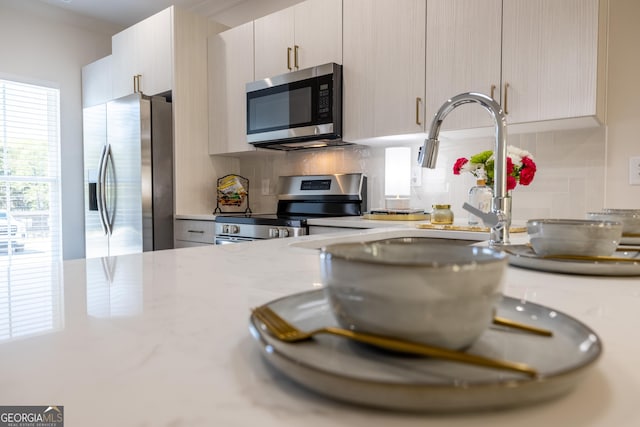 kitchen with backsplash and appliances with stainless steel finishes