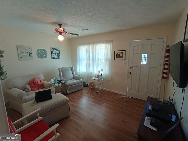 living room featuring a textured ceiling, hardwood / wood-style flooring, and ceiling fan