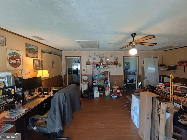 office space with ceiling fan, dark hardwood / wood-style floors, wood walls, a textured ceiling, and ornamental molding