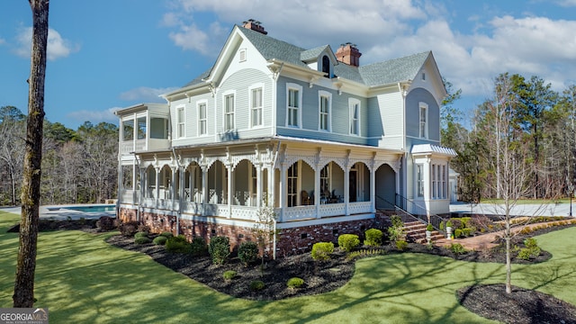 view of side of home featuring covered porch and a lawn