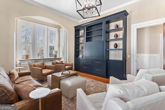 living room with a chandelier, light wood-type flooring, and ornamental molding