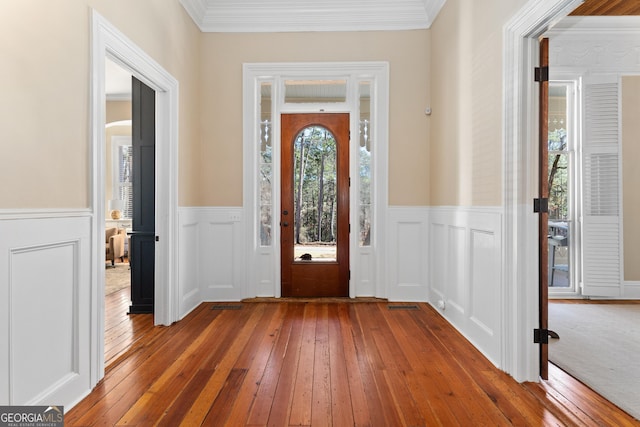 foyer with crown molding and light hardwood / wood-style flooring