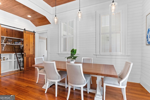 dining room featuring a barn door, dark hardwood / wood-style floors, vaulted ceiling, and wooden ceiling