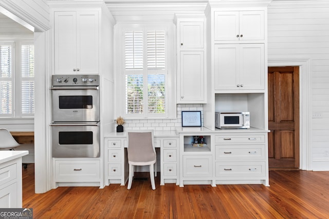 kitchen featuring white cabinets, stainless steel double oven, and dark hardwood / wood-style floors