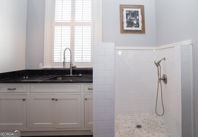 bathroom featuring a tile shower and vanity