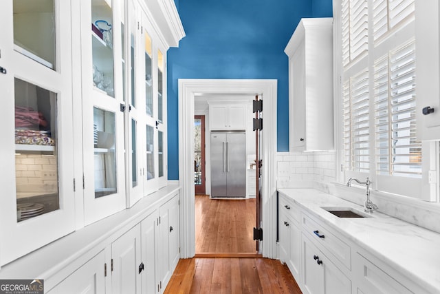 interior space featuring white cabinets, dark hardwood / wood-style floors, stainless steel built in refrigerator, and sink