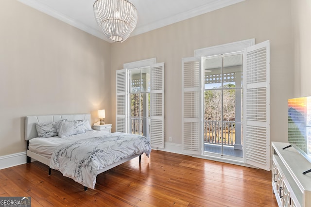 bedroom featuring access to outside, crown molding, a chandelier, and hardwood / wood-style flooring