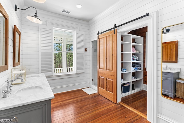 bathroom featuring vanity, wood walls, and wood-type flooring