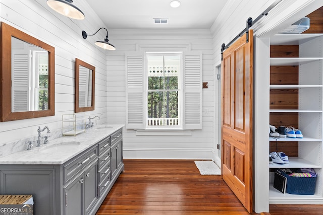 bathroom with hardwood / wood-style flooring, vanity, and wooden walls