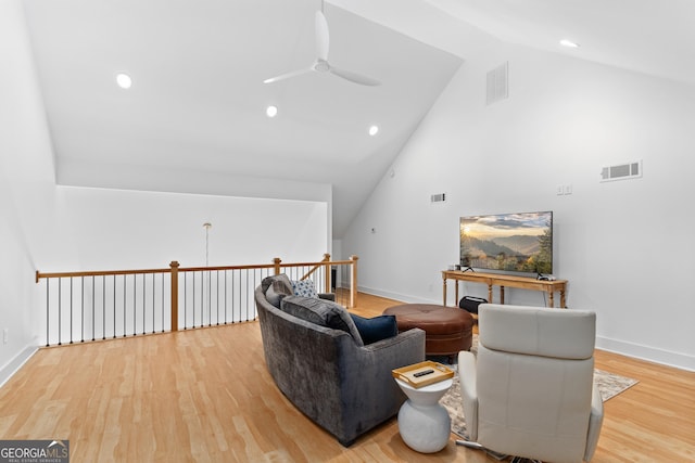 living room featuring ceiling fan, light wood-type flooring, and high vaulted ceiling