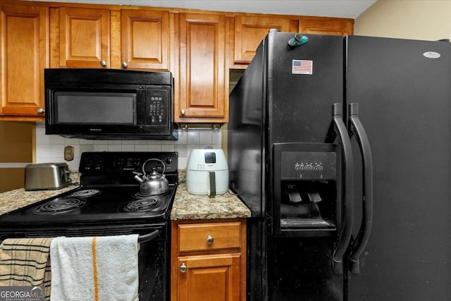 kitchen with light stone countertops, tasteful backsplash, and black appliances