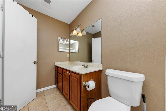 bathroom featuring toilet, vanity, and tile patterned floors