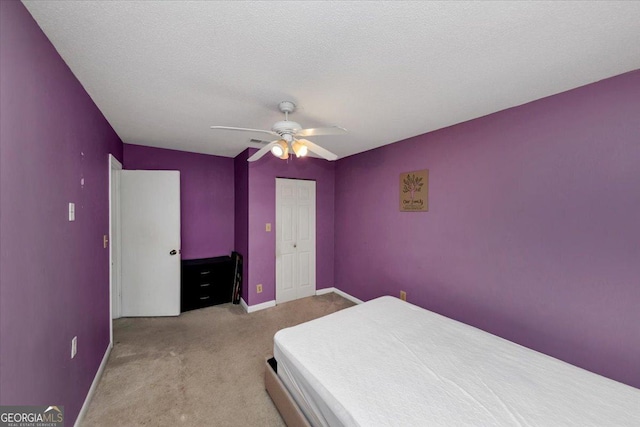 bedroom with light carpet, a textured ceiling, and ceiling fan