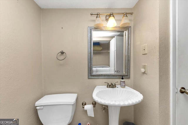 bathroom with a textured ceiling and toilet