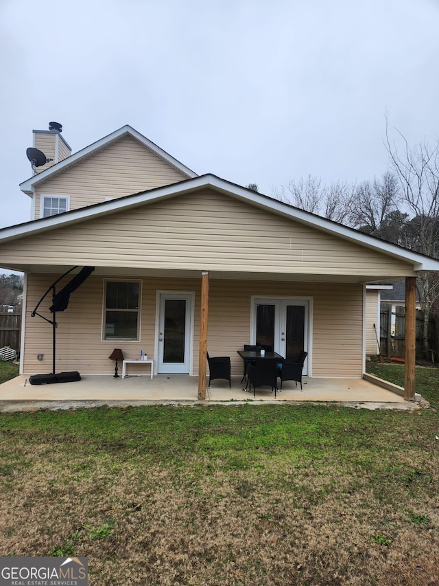 rear view of property with a yard and a patio