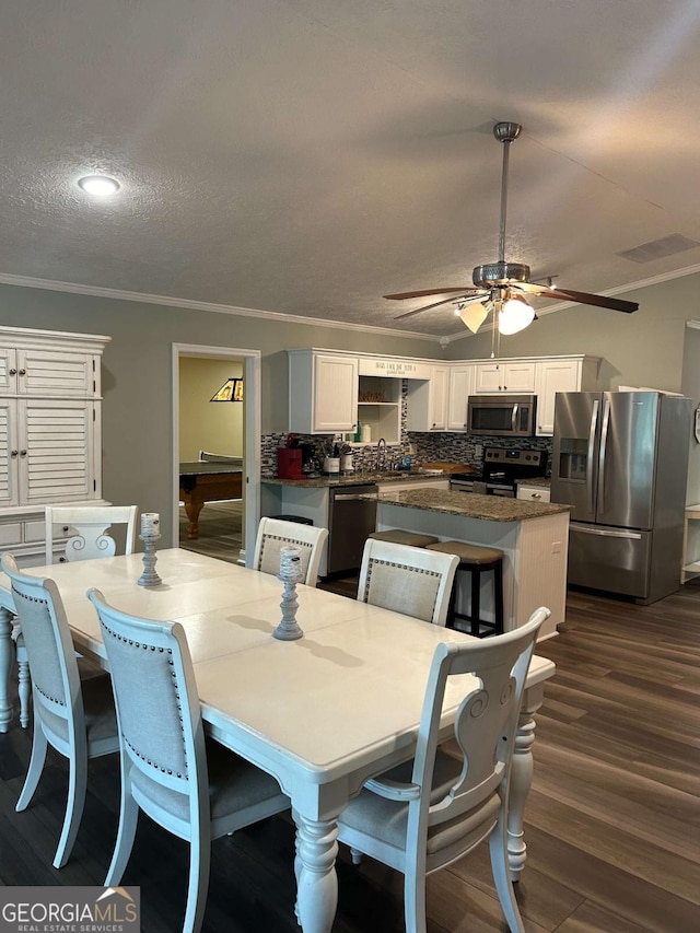 dining space with crown molding, billiards, dark hardwood / wood-style floors, ceiling fan, and a textured ceiling